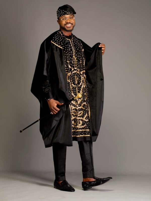 A happy African groom in a Black Agbada dress with his walking stick